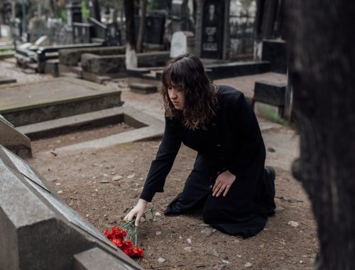A girl gives a flower to a grave
