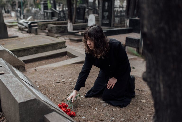 A girl gives a flower to a grave