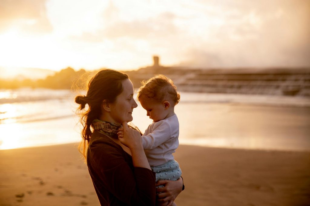 Woman holding child on beach